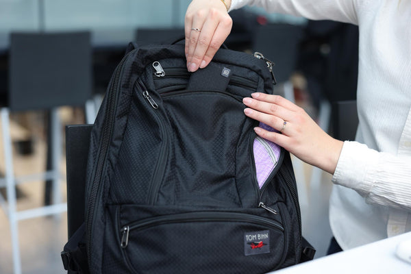 A person pulling a Minimalist Wallet from a Spectron Synik 26